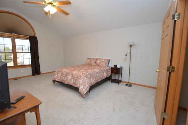 carpeted bedroom featuring baseboards, lofted ceiling, and a ceiling fan