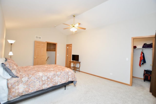 bedroom with a spacious closet, visible vents, baseboards, vaulted ceiling, and light carpet