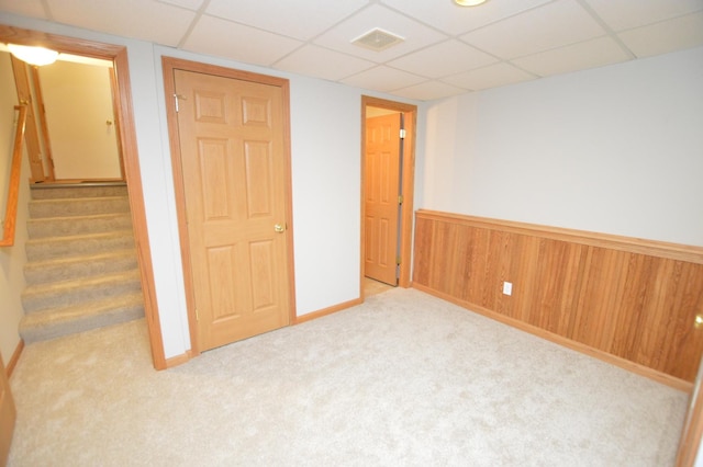 interior space featuring visible vents, wooden walls, stairway, a wainscoted wall, and a paneled ceiling