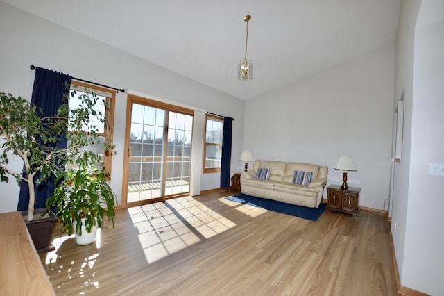 living room featuring wood finished floors, baseboards, and high vaulted ceiling