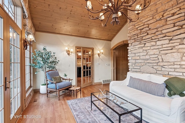 living room with french doors, wooden ceiling, wood finished floors, and an inviting chandelier