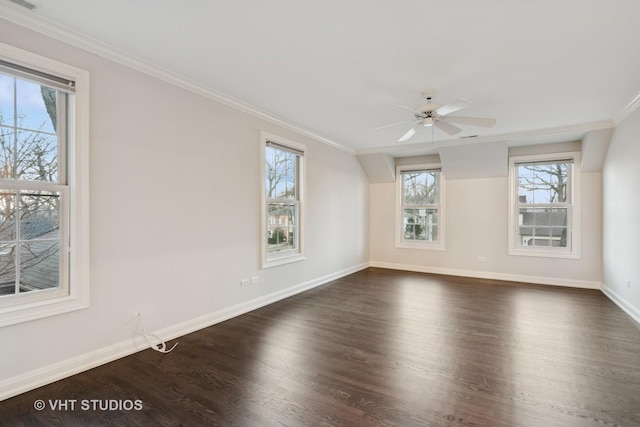 empty room with crown molding, dark wood finished floors, visible vents, ceiling fan, and baseboards