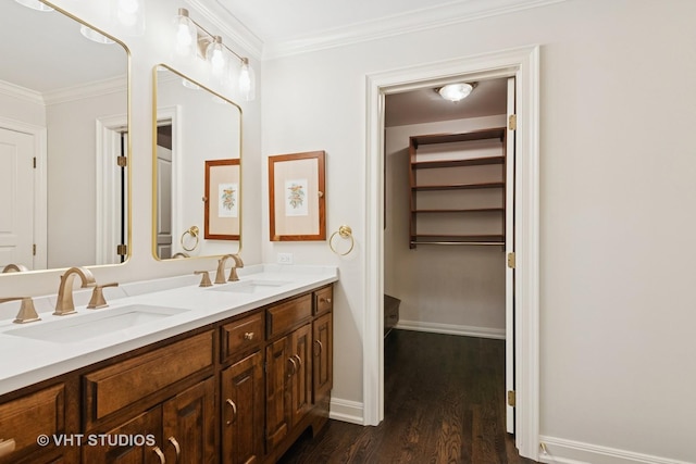 full bath with wood finished floors, ornamental molding, a sink, and baseboards