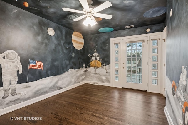 interior space with visible vents, baseboards, ceiling fan, and dark wood-type flooring