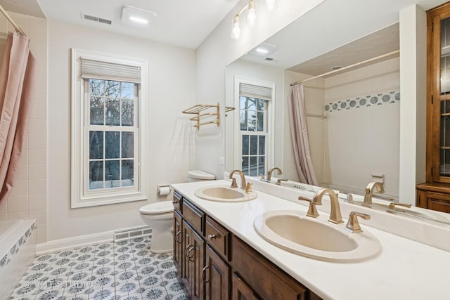 bathroom featuring toilet, visible vents, and a sink