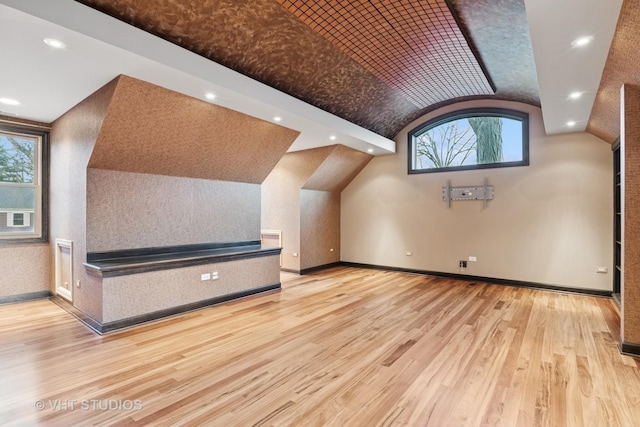 additional living space featuring lofted ceiling, light wood finished floors, baseboards, and recessed lighting