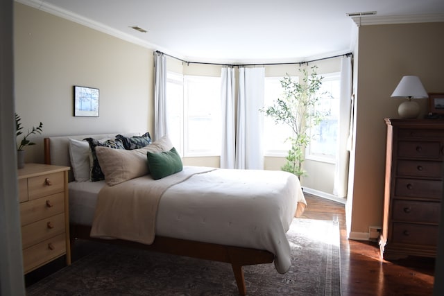 bedroom with visible vents, ornamental molding, and dark wood finished floors