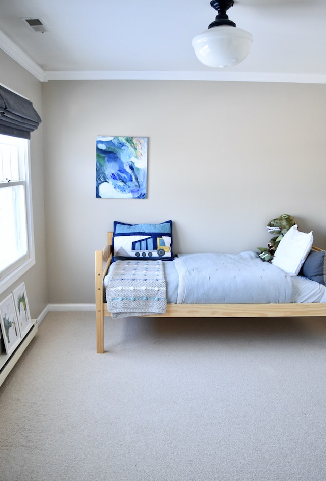 bedroom with ornamental molding, carpet, visible vents, and baseboards