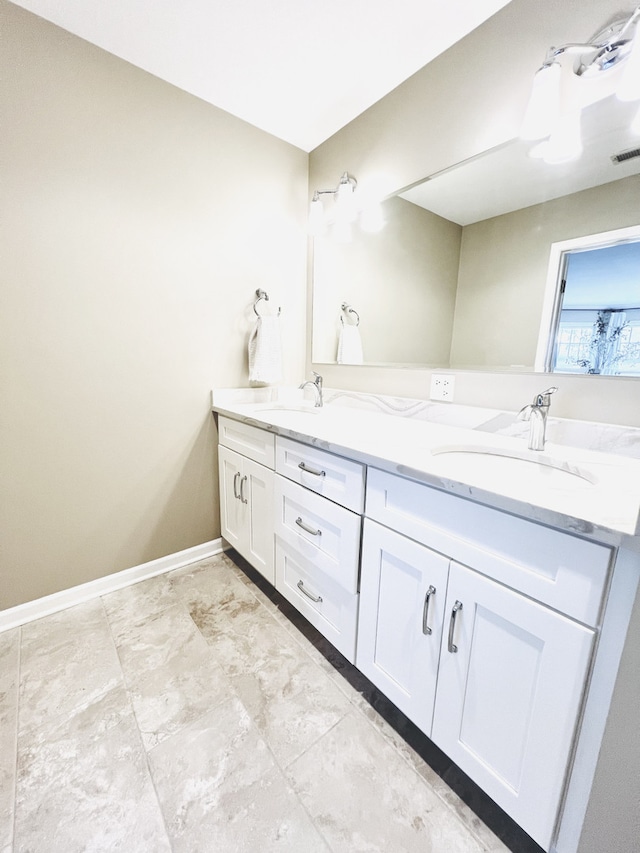 full bath with visible vents, a sink, baseboards, and double vanity