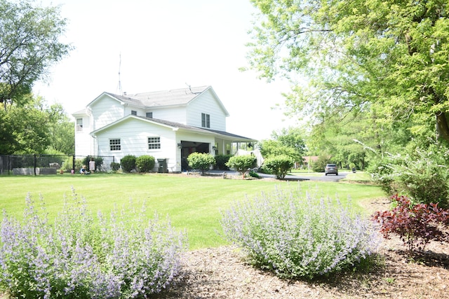 back of property with fence and a lawn