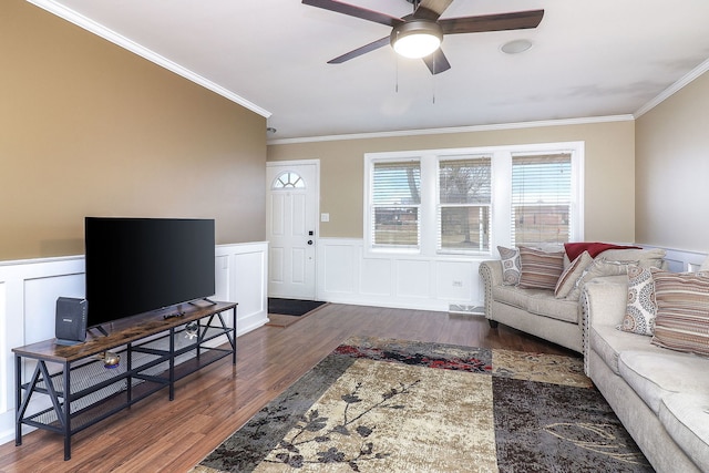 living room with a wainscoted wall, crown molding, a ceiling fan, and wood finished floors