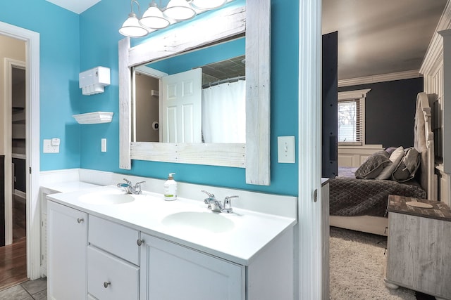 ensuite bathroom with a sink, connected bathroom, ornamental molding, and double vanity