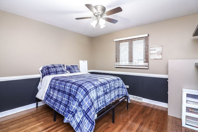 bedroom featuring visible vents, baseboards, and wood finished floors