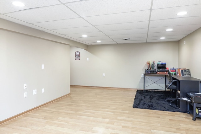 office space featuring light wood finished floors, a drop ceiling, recessed lighting, and baseboards