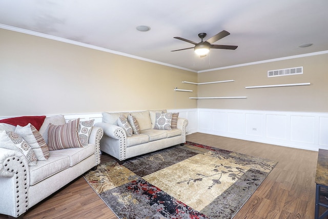 living room with visible vents, wainscoting, wood finished floors, and ornamental molding