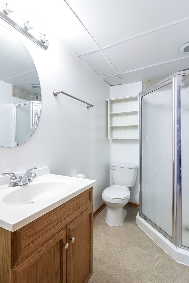 full bathroom featuring vanity, baseboards, tile patterned flooring, a shower stall, and toilet