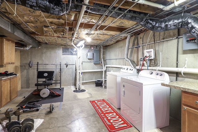 clothes washing area featuring electric panel and separate washer and dryer