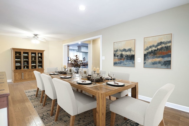 dining space featuring ceiling fan, baseboards, and light wood-style flooring