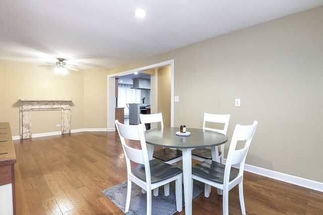 dining space with baseboards, wood finished floors, and a ceiling fan