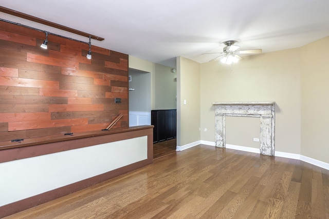 unfurnished living room with baseboards, ceiling fan, and wood finished floors