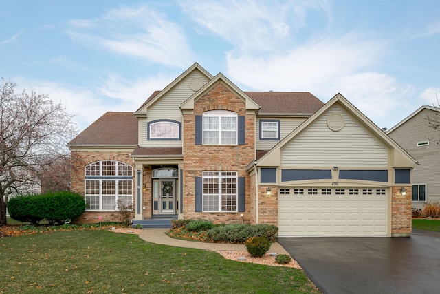 traditional-style house featuring aphalt driveway, brick siding, a shingled roof, an attached garage, and a front yard