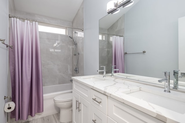 full bathroom featuring double vanity, shower / bath combo, a sink, and toilet