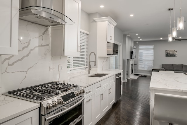 kitchen with light stone counters, extractor fan, stainless steel appliances, a sink, and white cabinets