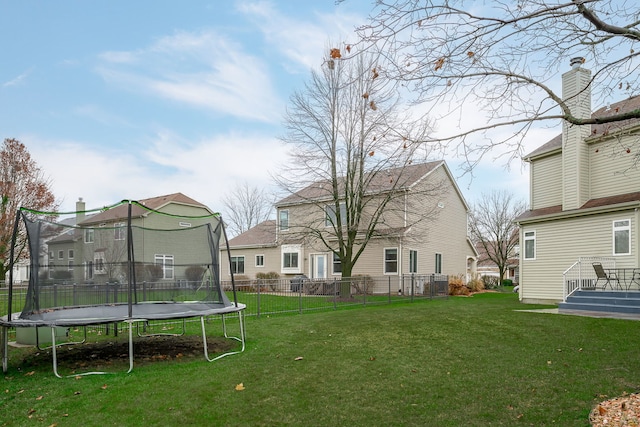 view of yard featuring a trampoline and fence