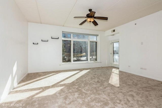 unfurnished room featuring carpet, visible vents, and a ceiling fan