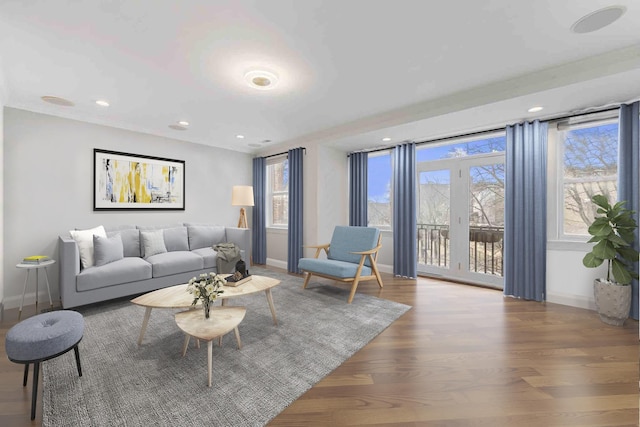 living area with recessed lighting, wood finished floors, baseboards, and a wealth of natural light