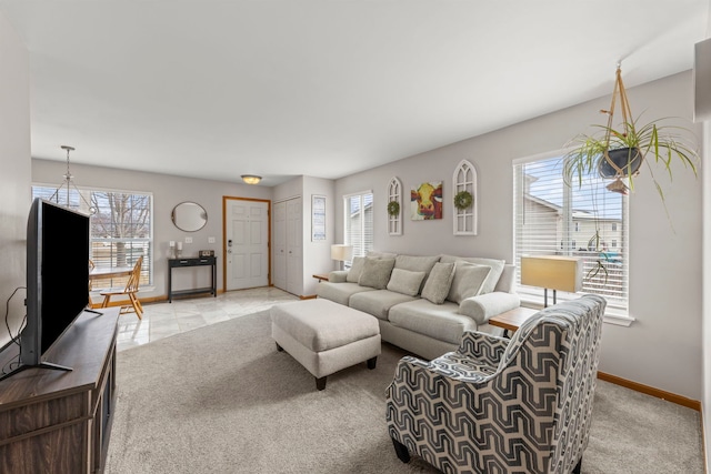 living room featuring a healthy amount of sunlight, light carpet, and baseboards