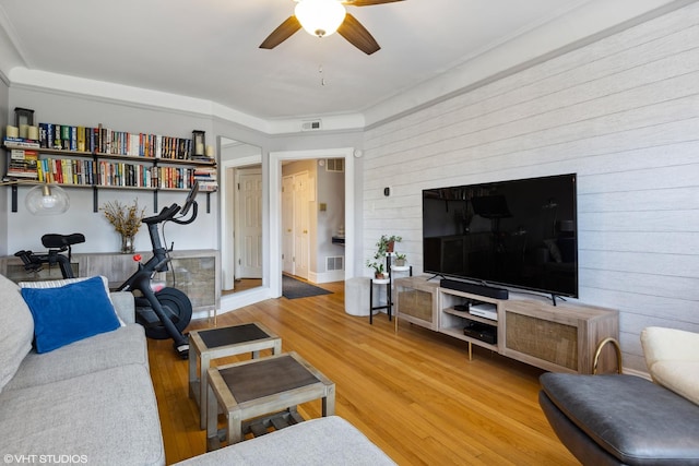 living area featuring visible vents, ceiling fan, and wood finished floors