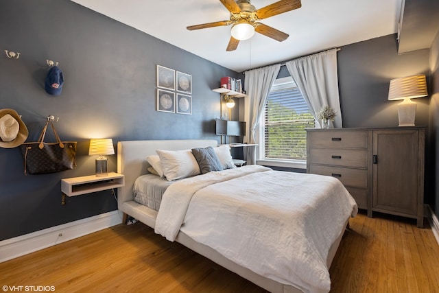 bedroom with wood finished floors, ceiling fan, and baseboards