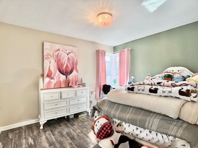 bedroom with dark wood-type flooring and baseboards