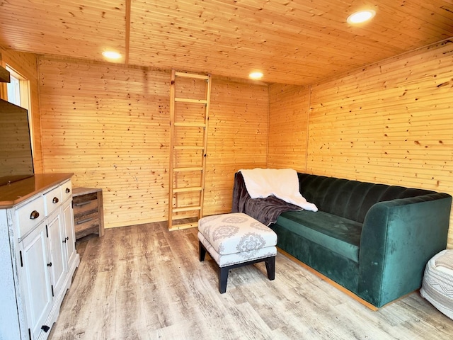 unfurnished room with light wood-type flooring, wooden ceiling, recessed lighting, and wood walls