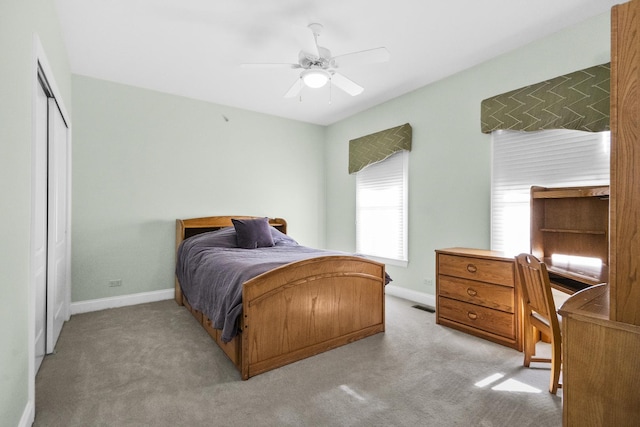 bedroom featuring light carpet, baseboards, and a closet