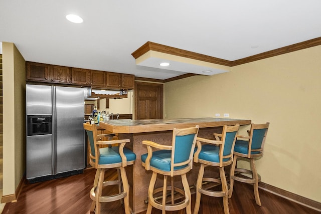 kitchen with a peninsula, crown molding, stainless steel refrigerator with ice dispenser, and dark wood-type flooring