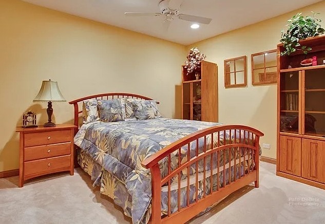 bedroom with light carpet, ceiling fan, and baseboards