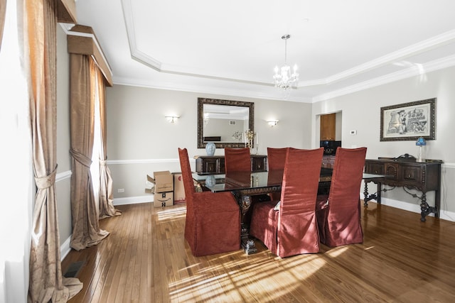 dining area featuring baseboards, crown molding, wood finished floors, and an inviting chandelier