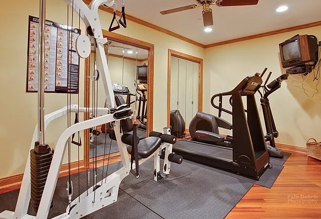 exercise room with recessed lighting, wood finished floors, a ceiling fan, baseboards, and crown molding