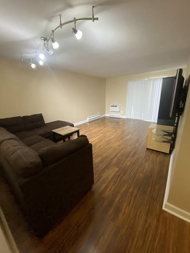 living room with baseboards, a baseboard heating unit, dark wood finished floors, and track lighting