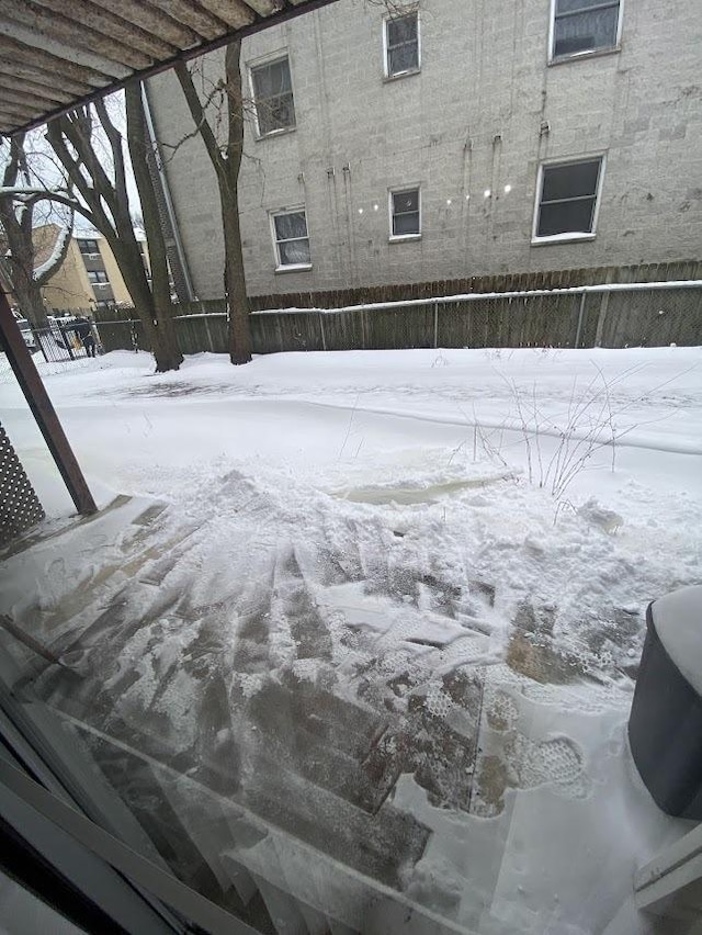 yard layered in snow featuring fence