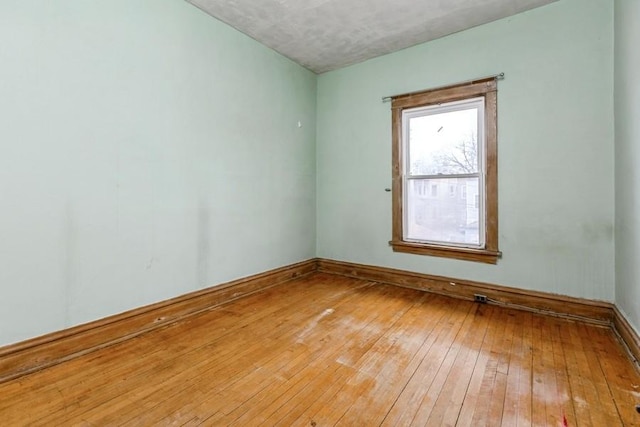 unfurnished room featuring baseboards and hardwood / wood-style floors