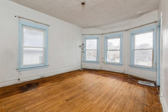 spare room featuring a textured ceiling and hardwood / wood-style flooring