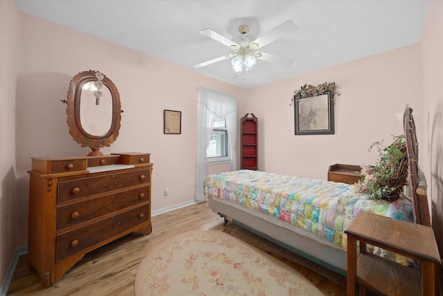 bedroom featuring baseboards, a ceiling fan, and light wood finished floors