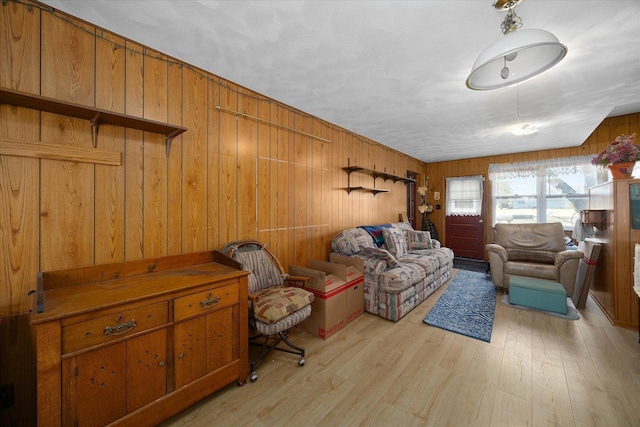 living area featuring wood walls and light wood-style floors