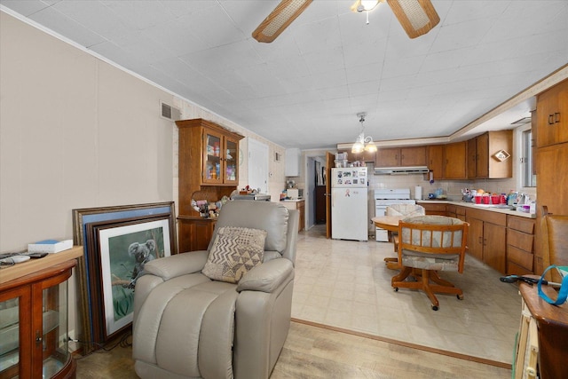 living area with visible vents, light floors, and a ceiling fan