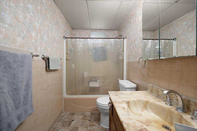 full bathroom with vanity, tile walls, shower / bath combination with curtain, and toilet