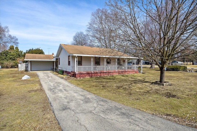 view of front of house with an outbuilding, a garage, covered porch, and a front yard