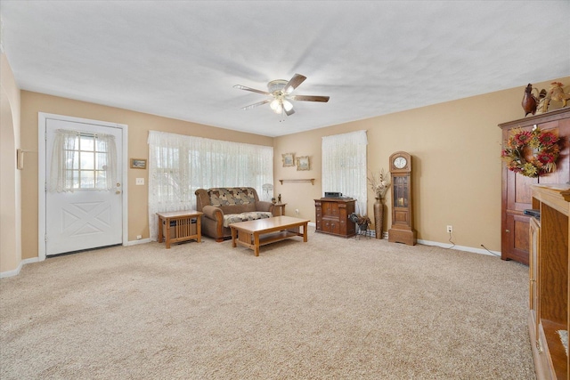 carpeted living room with baseboards and ceiling fan